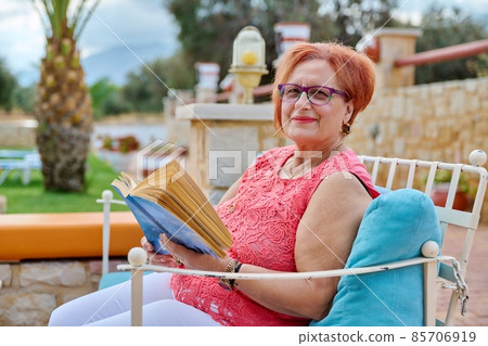 Elderly calm woman relaxing reading a book. 85706919