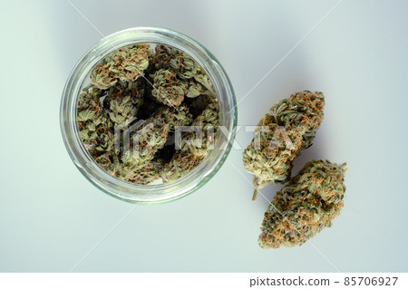 Marijuana buds in a jar. Medicinal cannabis stuff on white background, isolated, top view. Marijuana buds in a jar. Medicinal cannabis stuff on white background, isolated, top view. 85706927