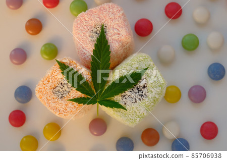 Turkish delight and colorful candy confetti with green cannabis leaf. Turkish delight and colorful candy confetti with green cannabis leaf. 85706938