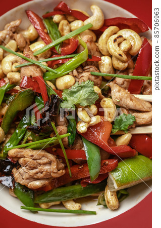 Delicious Thai dish with cashew nuts in red plate and grey clay background from above 85706963