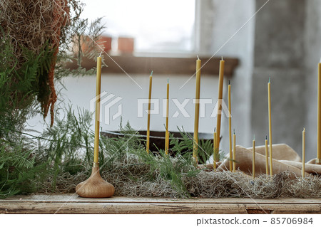 Table setting with Handmade candles on rustic old wood table and wood accessories in earth tones boho style Table setting with Handmade candles on rustic old wood table and wood accessories in earth tones boho style 85706984