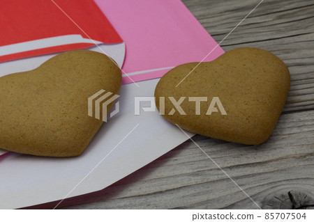 two heart shaped cookies, purple and red envelopes on a wooden rustic background. Valentine's Day, greeting card, pastry, copy space, top view, love concept, Engagement, horizontal. 85707504