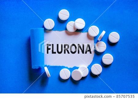 Covid-19 corona and flu flurona symbol. The concept word flurona appearing behind torn blue paper. White pills. Beautiful blue background. Medical, covid-19 corona and flu flurona concept. Copy space. 85707535