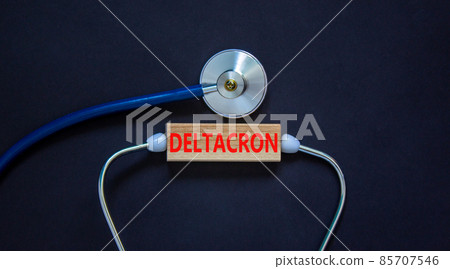 Covid-19 corona deltacron variant symbol. The concept word deltacron on wooden block and stethoscope. Beautiful black background. Medical, covid-19 corona deltacron variant concept. Copy space. 85707546