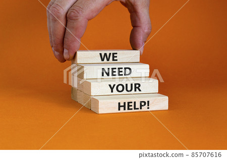 We need your help symbol. Wooden blocks with concept words 'We need your help'. Businessman hand. Beautiful orange background. Business, support and we need your help concept. Copy space. We need your help symbol. Wooden blocks with concept words 'We need your help'. Businessman hand. Beautiful orange background. Business, support and we need your help concept. Copy space. 85707616