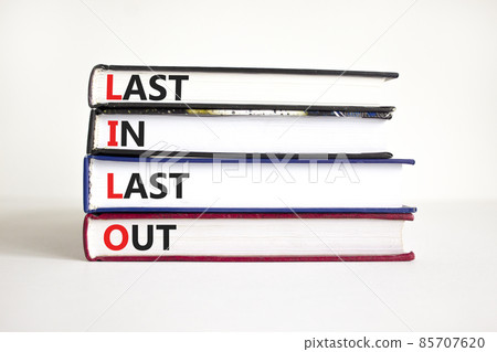 LILO last in last out symbol. Concept words LILO last in last out on books. Beautiful white table, white background. Businessman hand. Business and LILO last in and out concept. Copy space. 85707620