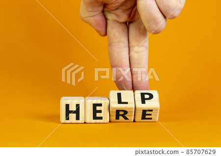 Help is here symbol. Businessman turns cubes and changes the word help to here. Beautiful orange background, copy space. Business, motivational and help is here concept. Help is here symbol. Businessman turns cubes and changes the word help to here. Beautiful orange background, copy space. Business, motivational and help is here concept. 85707629