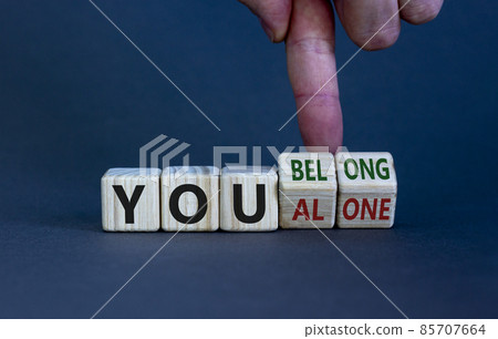 You alone or belong symbol. Businessman turns cubes and changes words you alone to you belong. Beautiful grey background. Business, psychology and you alone or belong concept. Copy space. You alone or belong symbol. Businessman turns cubes and changes words you alone to you belong. Beautiful grey background. Business, psychology and you alone or belong concept. Copy space. 85707664
