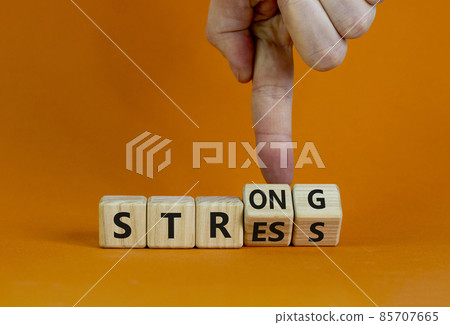 Strong stress symbol. Businessman turns wooden cubes with words 'strong stress'. Beautiful orange background, copy space. Business and strong stress concept. Strong stress symbol. Businessman turns wooden cubes with words 'strong stress'. Beautiful orange background, copy space. Business and strong stress concept. 85707665