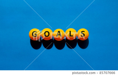 Goals symbol. The concept word 'goals' on orange table tennis balls. Beautiful blue table, blue background. Business and goals or goal concept. 85707666