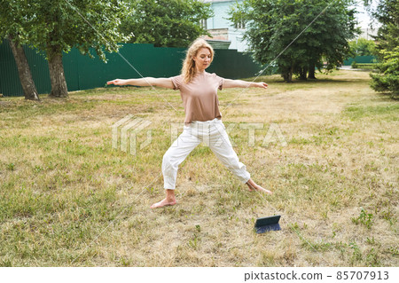 Woman at backyard. Online yoga school. Active vacation. Blonde hair. People 85707913