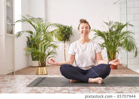 Young woman doing yoga exercise at home. Health care online lessons Young woman doing yoga exercise at home. Health care online lessons 85707944