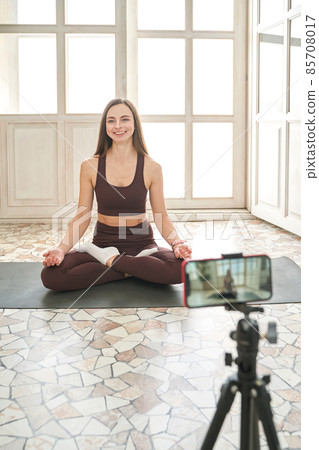 Young woman going yoga exercise at home. Health care online lessons Young woman going yoga exercise at home. Health care online lessons 85708017