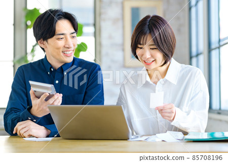 一對年輕夫婦在家查看收據時計算的最終納稅申報表的圖像 85708196