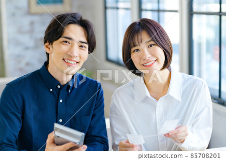 一對年輕夫婦在家查看收據時計算的最終納稅申報表的圖像 85708201
