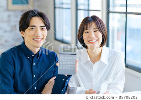 一對年輕夫婦在家查看收據時計算的最終納稅申報表的圖像 一對年輕夫婦在家查看收據時計算的最終納稅申報表的圖像 85708202