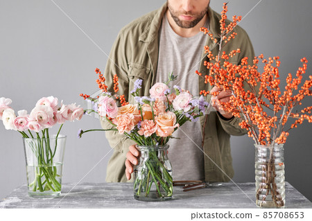 Portrait of a Male florist. Flowers bunch, set for home. Fresh cut flowers for decoration home. European floral shop. Delivery fresh cut flower. Portrait of a Male florist. Flowers bunch, set for home. Fresh cut flowers for decoration home. European floral shop. Delivery fresh cut flower. 85708653