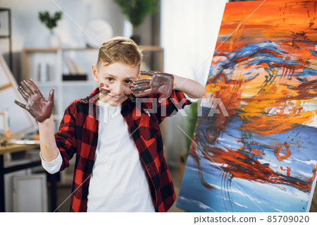 Cute boy posing near his creative pattern on easel 85709020