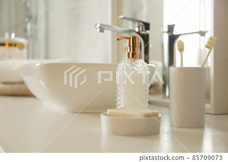 Toiletries near vessel sink in modern bathroom 85709073