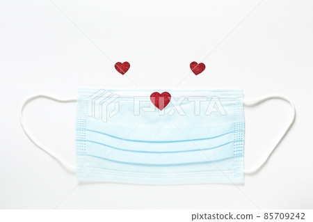 Medical and covid concept of Saint Valentine Day, red little heart on protection mask looking like funny animal muzzle Medical and covid concept of Saint Valentine Day, red little heart on protection mask looking like funny animal muzzle 85709242