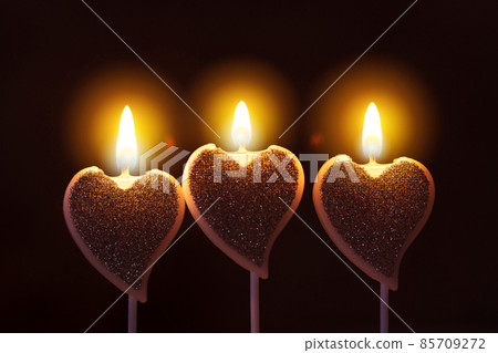 Valentine day greeting card with three heart-shaped burning glowing candles with warm flame 85709272