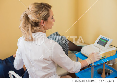 beautiful gynecologist examines the medical devices. The patient lies on the couch 85709323