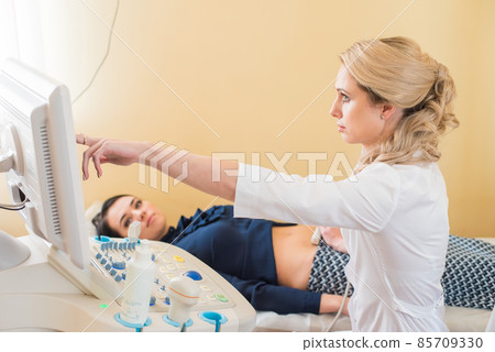beautiful gynecologist examines the medical devices. The patient lies on the couch beautiful gynecologist examines the medical devices. The patient lies on the couch 85709330