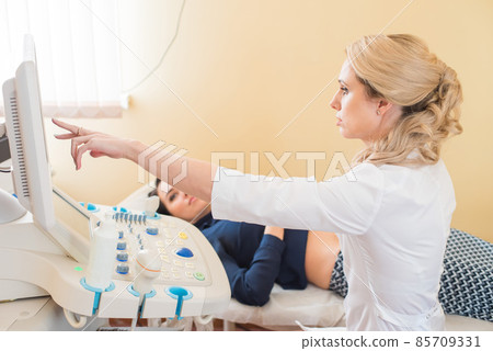 beautiful gynecologist examines the medical devices. The patient lies on the couch beautiful gynecologist examines the medical devices. The patient lies on the couch 85709331