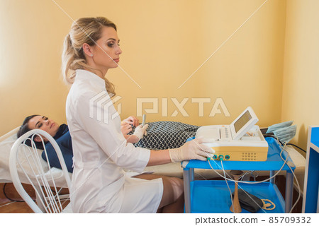 beautiful gynecologist examines the medical devices. The patient lies on the couch beautiful gynecologist examines the medical devices. The patient lies on the couch 85709332