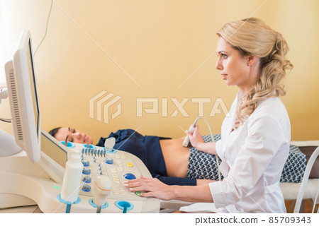 beautiful gynecologist examines the medical devices. The patient lies on the couch 85709343