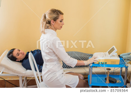 beautiful gynecologist examines the medical devices. The patient lies on the couch beautiful gynecologist examines the medical devices. The patient lies on the couch 85709364