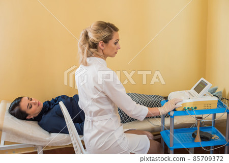 beautiful gynecologist examines the medical devices. The patient lies on the couch 85709372