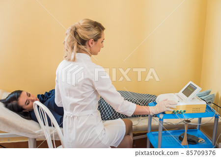 beautiful gynecologist examines the medical devices. The patient lies on the couch 85709376