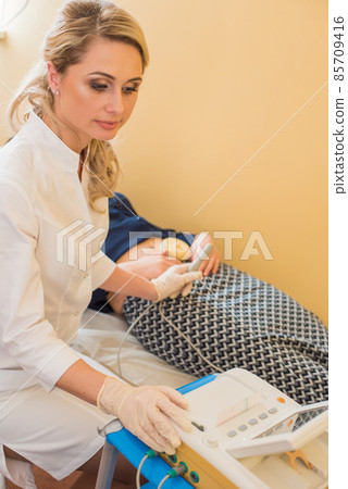 beautiful gynecologist examines the medical devices. The patient lies on the couch 85709416