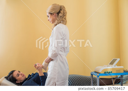 beautiful gynecologist examines the medical devices. The patient lies on the couch 85709417