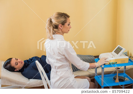 beautiful gynecologist examines the medical devices. The patient lies on the couch beautiful gynecologist examines the medical devices. The patient lies on the couch 85709422