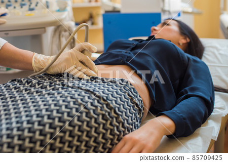 beautiful gynecologist examines the medical devices. The patient lies on the couch 85709425
