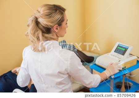 beautiful gynecologist examines the medical devices. The patient lies on the couch 85709426