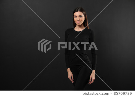 Woman wearing thermal underwear on black background. Space for text 85709789