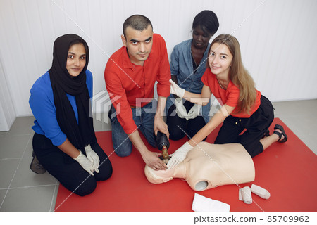Students of different nationalities learn to provide medical care on a mannequin. Students of different nationalities learn to provide medical care on a mannequin. 85709962