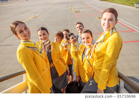 Cheerful women stewardesses standing on airplane stairs 85710696