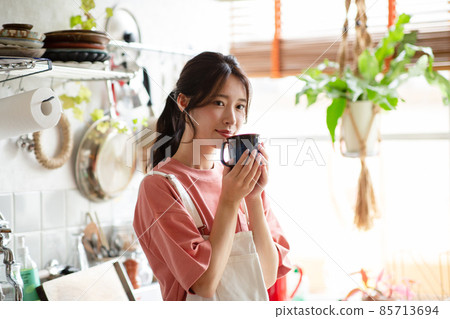 A woman drinking coffee in the kitchen A woman drinking coffee in the kitchen 85713694