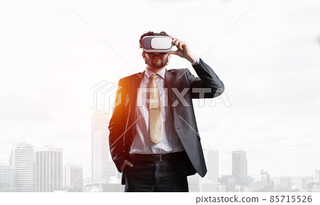 Handsome elegant businessman experiencing impressive virtual reality and business city at backdrop 85715526