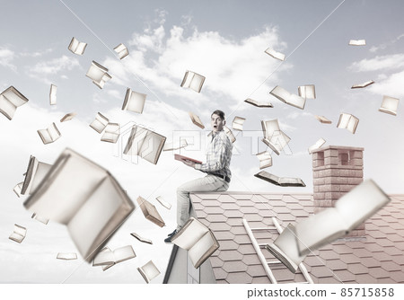 Man reading book and many of them flying in air 85715858
