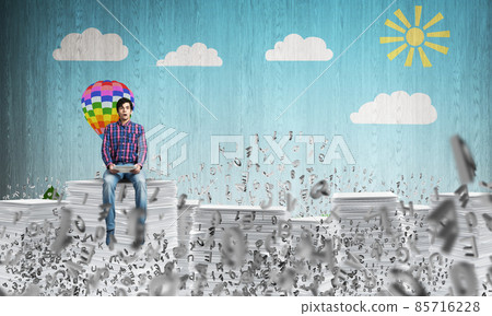 Young man sitting on pile of paper documents. Young man sitting on pile of paper documents. 85716228