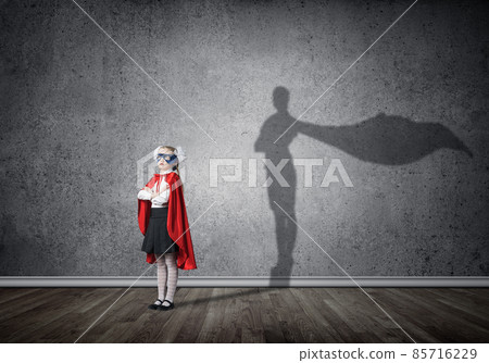 Girl power concept with cute kid guardian and shadow on wall. Mixed media Girl power concept with cute kid guardian and shadow on wall. Mixed media 85716229