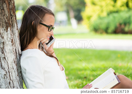 woman in the park with phone 85716719