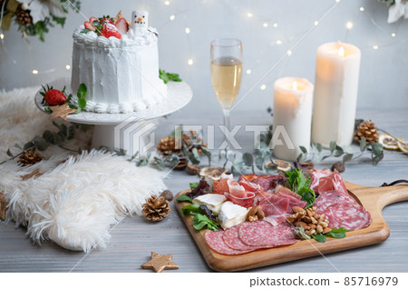 Christmas dinner with shining candles and illuminations | Assorted prosciutto, chanmery and strawberry cake Christmas dinner with shining candles and illuminations | Assorted prosciutto, chanmery and strawberry cake 85716979