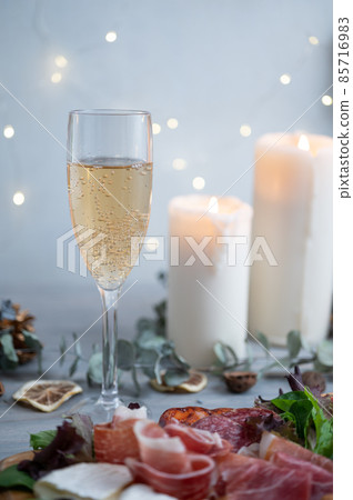 Christmas party with assorted prosciutto and chanmery | Background with shining candles and illuminations 85716983