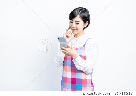 Housewife operating a smartphone Housewife operating a smartphone 85718518